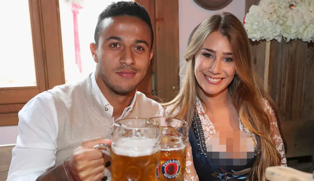 Gelandang Bayern Munchen, Thiago Alcantara bersama istrinya, Julia Vigas berpose saat menghadiri Festival Oktoberfest di Munich, Jerman, (2/9). (REUTERS/Alexander Hassenstein)