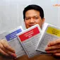 Ketua KPU Husni Kamil Manik saat menunjukkan kertas suara sebelum mencoblos di bilik suara tempat pencoblosan (Liputan6.com/Miftahul Hayat)