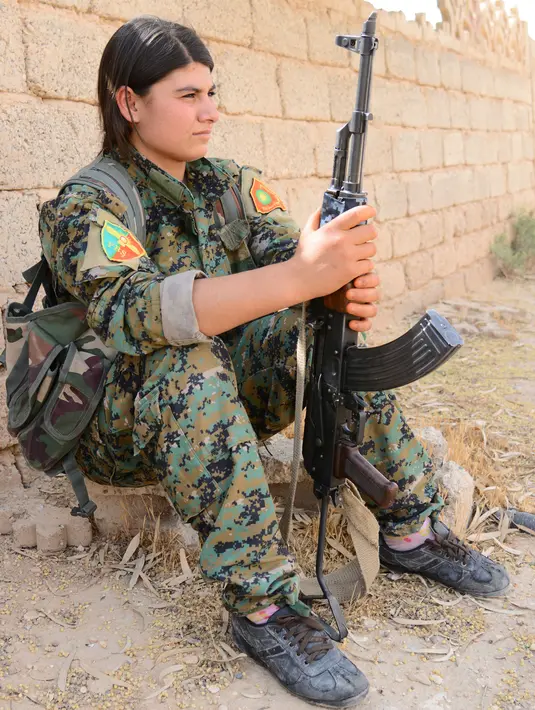 Prajurit perempuan Yazidi dari Unit Perlawanan Sinjar (YBS) memegang senapan AK47 saat Berpatroli penjagaan wilayah Pegunungan Sinjar dari serangan militan ISIS di Irak (6/6). (Reuters/Stringer)