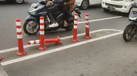 Sejumlah pengendara motor melewati jalur sepeda di Jakarta. Stick Cone pembatas jalur banyak yang rusak dan copot. (Merdeka.com)