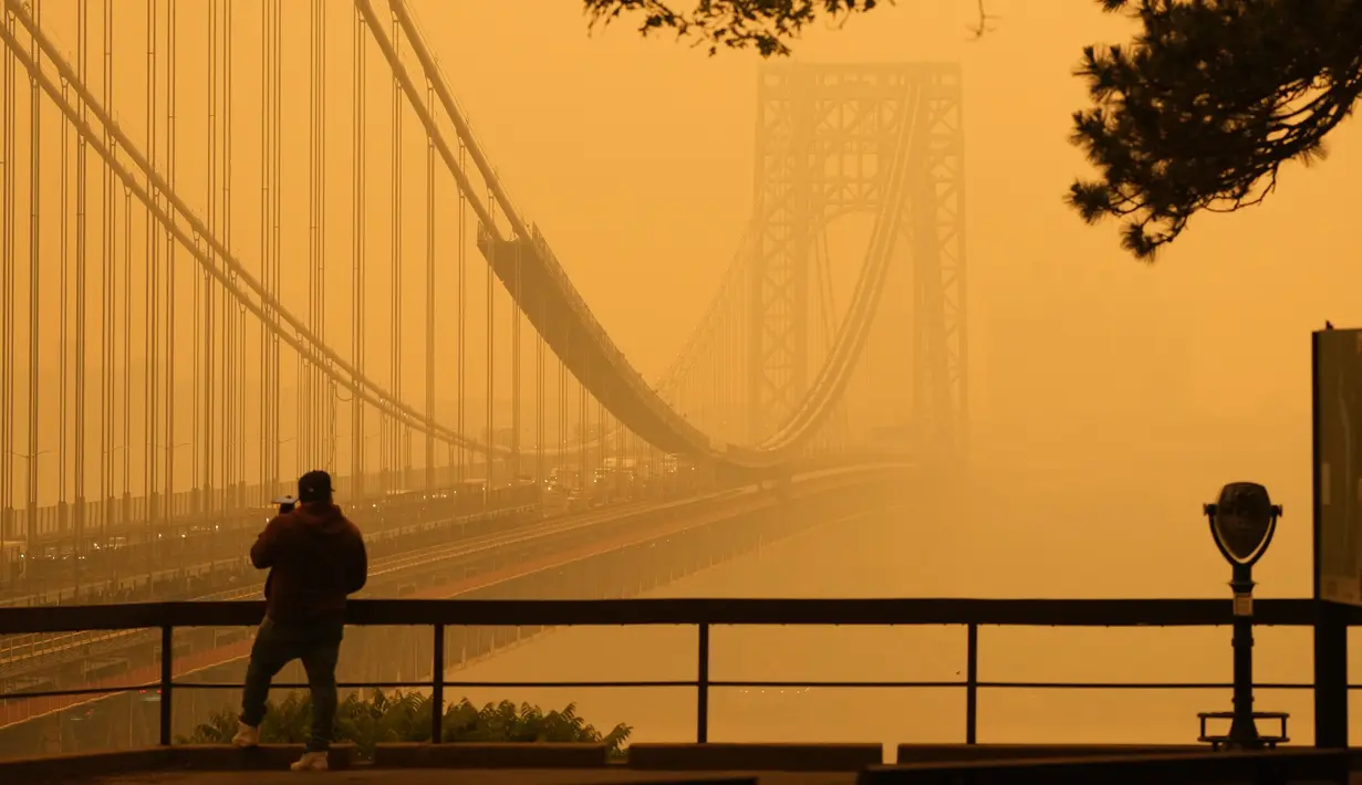 Orang-orang banyak yang mengenakan masker, melewati landmark-landmark yang sudah tidak asing lagi yang tertutup kabut asap.  (AP Photo/Seth Wenig)