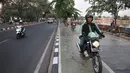Pengendara sepeda motor melintasi trotoar Danau Sunter, Jakarta, Senin (22/7/2019). Tidak adanya fasilitas parkir di kawasan tersebut menyebabkan pengunjung Danau Sunter memarkirkan sepeda motor mereka di sepanjang trotoar sehingga mengganggu akses pejalan kaki. (merdeka.com/Iqbal Nugroho)