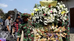 Anggota TNI membawa Karangan bunga di lokasi jatuhnya pesawat hercules C 130 di jalan jamin ginting, Medan, Kamis (2/7/2015). Karangan bunga sebagai simbol duka cita atas peristiwa yang merenggut ratusan nyawa. (Liputan6.com/Johan Tallo)