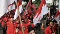 Kader PDIP membawa bendera saat menuju Kantor KPU, Jakarta, Selasa (17/7). Kedatangan anggota PDIP untuk mendaftarkan bakal caleg di KPU diiringi pawai bendera, ondel-ondel, musik hingga wanita cantik. (Merdeka.com/Iqbal S. Nugroho)