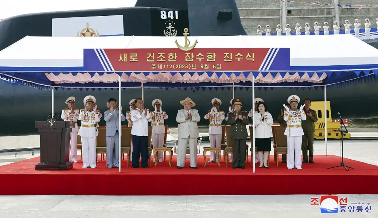 Gambar ini diambil pada tanggal 6 September 2023 dan dirilis oleh Korean Central News Agency (KCNA) pada tanggal 8 September 2023 menunjukkan Pemimpin Korea Utara Kim Jong Un (tengah) saat peluncuran "kapal selam serang nuklir taktis" No. 841 di lokasi yang dirahasiakan di Korea Utara. (STR/KCNA VIA KNS/AFP)