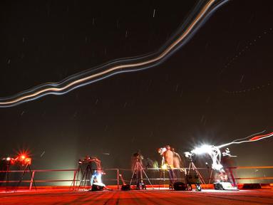 Foto dengan teknik long eksposur menunjukkan para fotografer bekerja dari atap gedung perakitan kendaraan saat roket SpaceX Falcon 9 dengan pesawat ruang angkasa Crew Dragon milik perusahaan tersebut mengosongkan bahan bakar sebelum peluncuran yang telah digosok dari pad 39A untuk misi Crew-6 di Kennedy Space Center NASA di Cape Canaveral, Florida, pada tanggal 27 Februari 2023. (CHANDAN KHANNA/AFP)