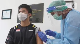 Petugas medis menyuntikan vaksin COVID-19 kepada Atlet Wushu Edgar Xavier Marvelo di Jakarta, Jumat (12/3/2021). Kemenpora bersama Kemenkes melakukan vaksinasi COVID-19 dosis ke-2 kepada insan olah raga nasional dengan menyasar 820 orang secara bertahap. (Liputan6.com/Herman Zakharia)