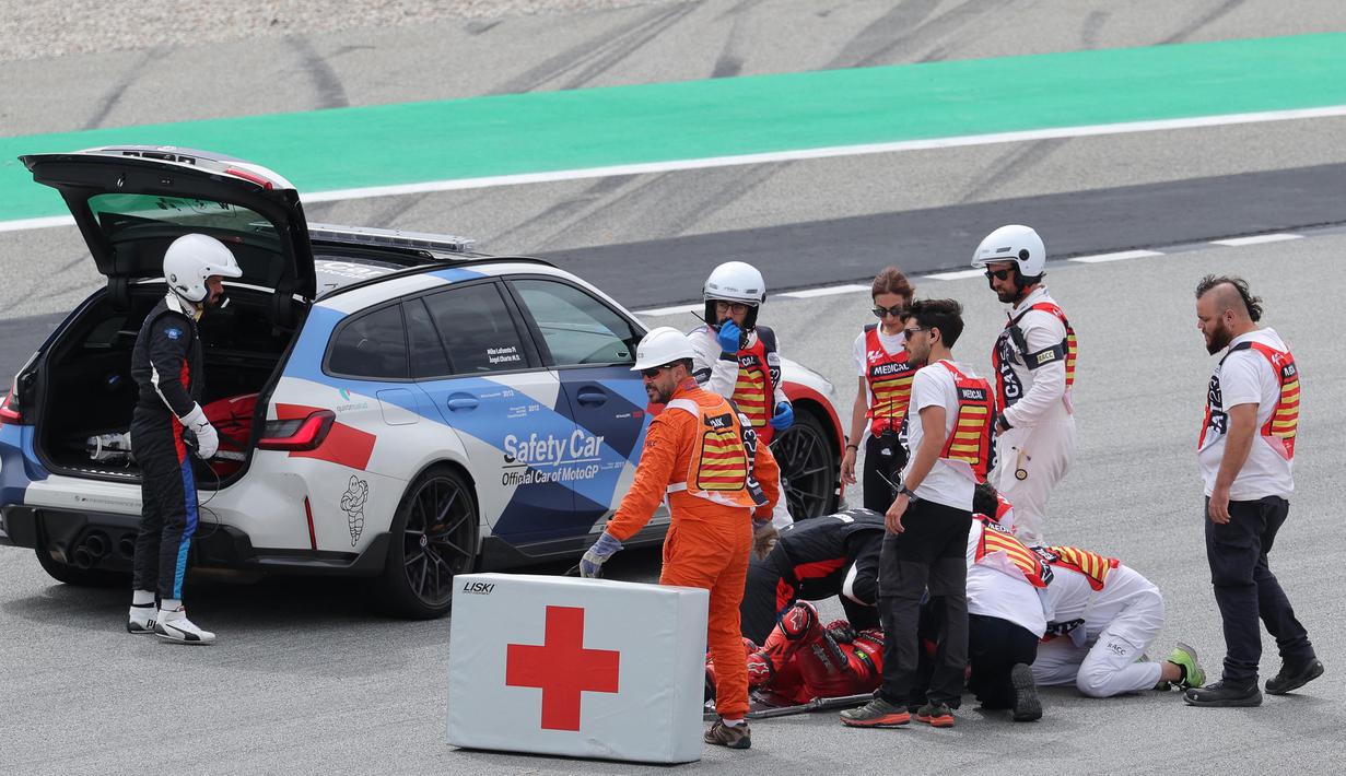 Francesco Bagnaia sempat terlempar dari motornya dan dalam tayangan ulang, tampak bagian kaki juara dunia MotoGP 2022 itu terlindas motor dari belakang. (AFP/Lluis Gene)
