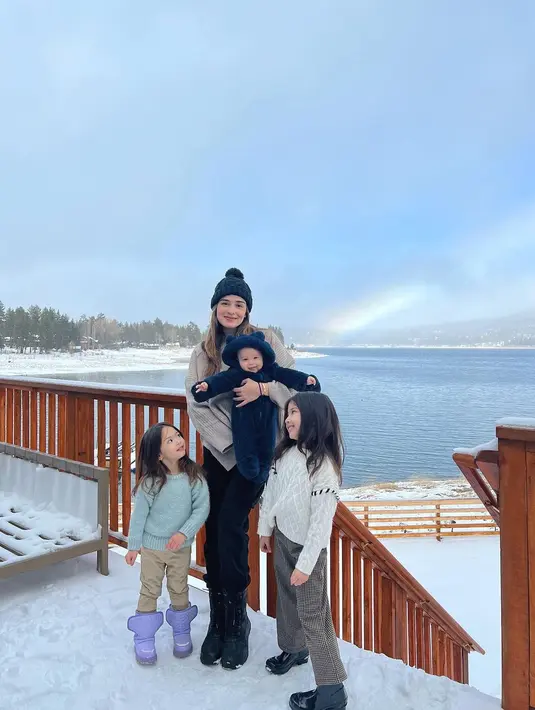 Membagikan momen liburan bersama keluarganya, lihat potret kemesraan Yasmine Wildblood bersama ketiga anaknya. Menggendong anaknya yang paling kecil, Yasmine berpose bersama kedua anak perempuannya mengenakan atasan rajut berwarna netral dengan celana panjang, high boots, dan beanie hitam. Foto: Instagram.