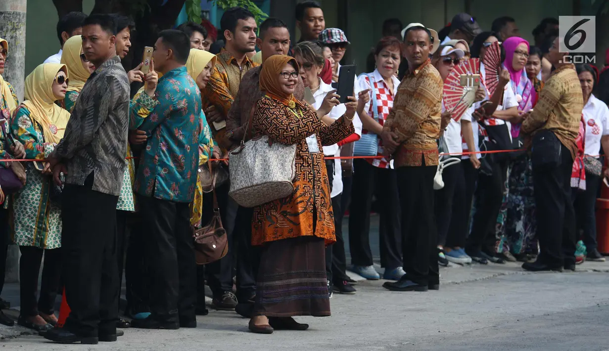 Sejumlah relawan menyaksikan prosesi kirab kereta kencana pernikahan putri Presiden Jokowi,  Kahiyang Ayu-Bobby Nasution saat menuju Gedung Graha Saba di Surakarta, Rabu (8/11). (Liputan6.com/Angga Yuniar)