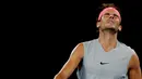 Petenis Spanyol, Rafael Nadal menahan sakit saat bertanding melawan petenis Kroasia, Marin Cilic di perempat final Australia Terbuka 2018, Selasa (23/1). Nadal harus tersingkir di Australia Terbuka karena mengalami cedera paha atas. (AP/Dita Alangkara)