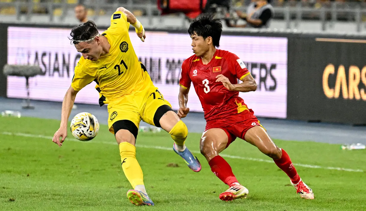 Pemain Malaysia, Dion Cools (kiri) berebut bola dengan pemain Vietnam, Nguyen Van Vi dalam laga Grup F Kualifikasi Piala Asia 2027 di Stadion Nasional Bukit Jalil, Kuala Lumpur, Malaysia, Selasa (10/06/2025). (AP Photo/Vincent Thian)