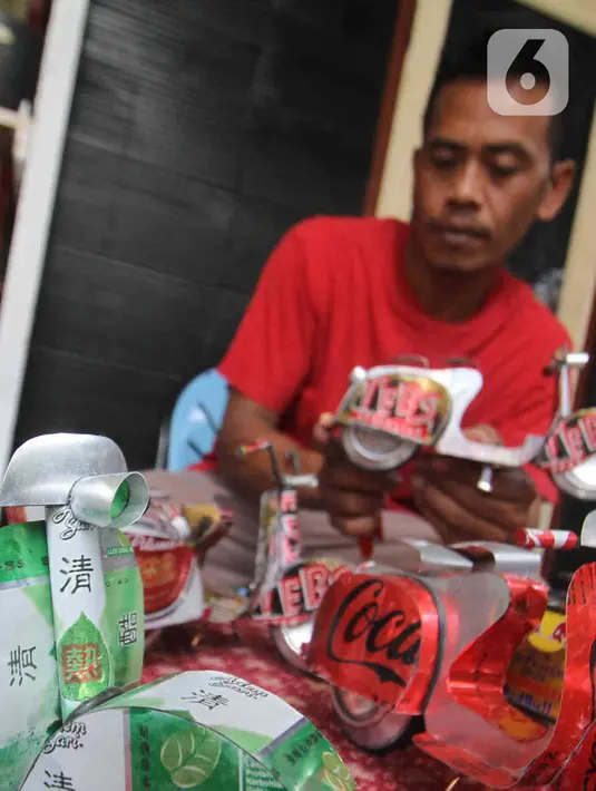 Perajin Ogifson Harianja, menyelesaikan miniatur vespa dari kaleng bekas, Jakarta, Jumat (7/1/2022). Pemerintah melalui Kemenko Perekonomian telah mengumumkan bahwa plafon penyaluran KUR 2022 ditingkatkan menjadi Rp373,17 triliun, dengan suku bunga tetap sebesar 6 persen. (Liputan6.com/Angga Yuniar)