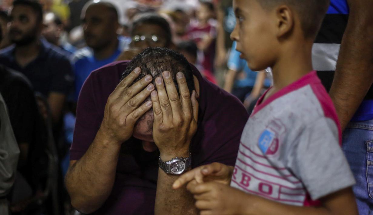 Seorang fans Mesir memegang kepala saat timnya kebobolan dari Rusia pada Piala Dunia 2018 di Nile delta village, Nagrig, Mesir, (19/6/2018). Rusia menang 3-1. (AP/Islam Safwat)