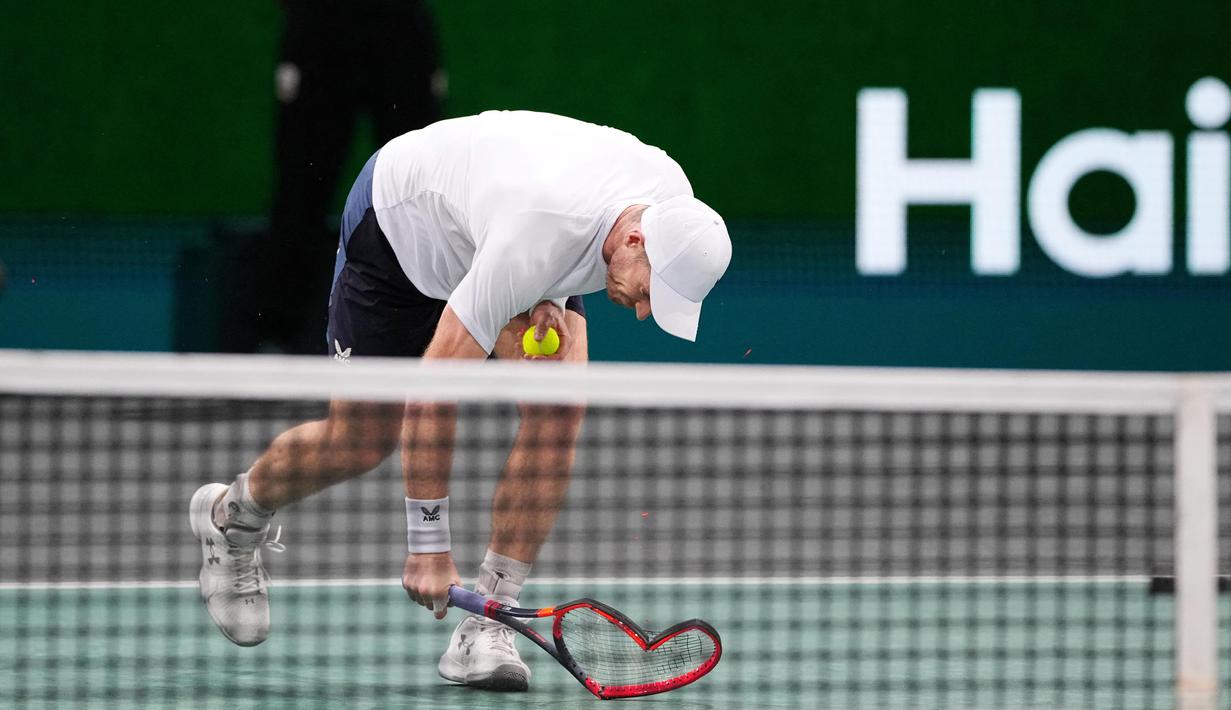 Petenis Skotlandia, Andy Murray, mematahkan raketnya setelah ditaklukkan petenis Australia, Alex De Minaur, pada laga Paris Masters di Accor Arena, Paris, Senin (30/10/2023). Murray takluk dengan skor 7-6, 4-6, dan 7-5. (AFP/ Dimitar Dilkoff)
