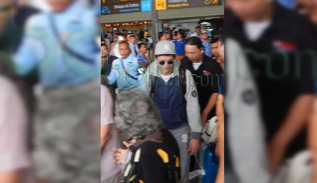 Valentino Rossi terlihat santai di tengah keramaian terminal kedatangan Bandara Ngurah Rai, Denpasar, Bali, Senin (25/1/2016). (Bola.com/Eksklusif)