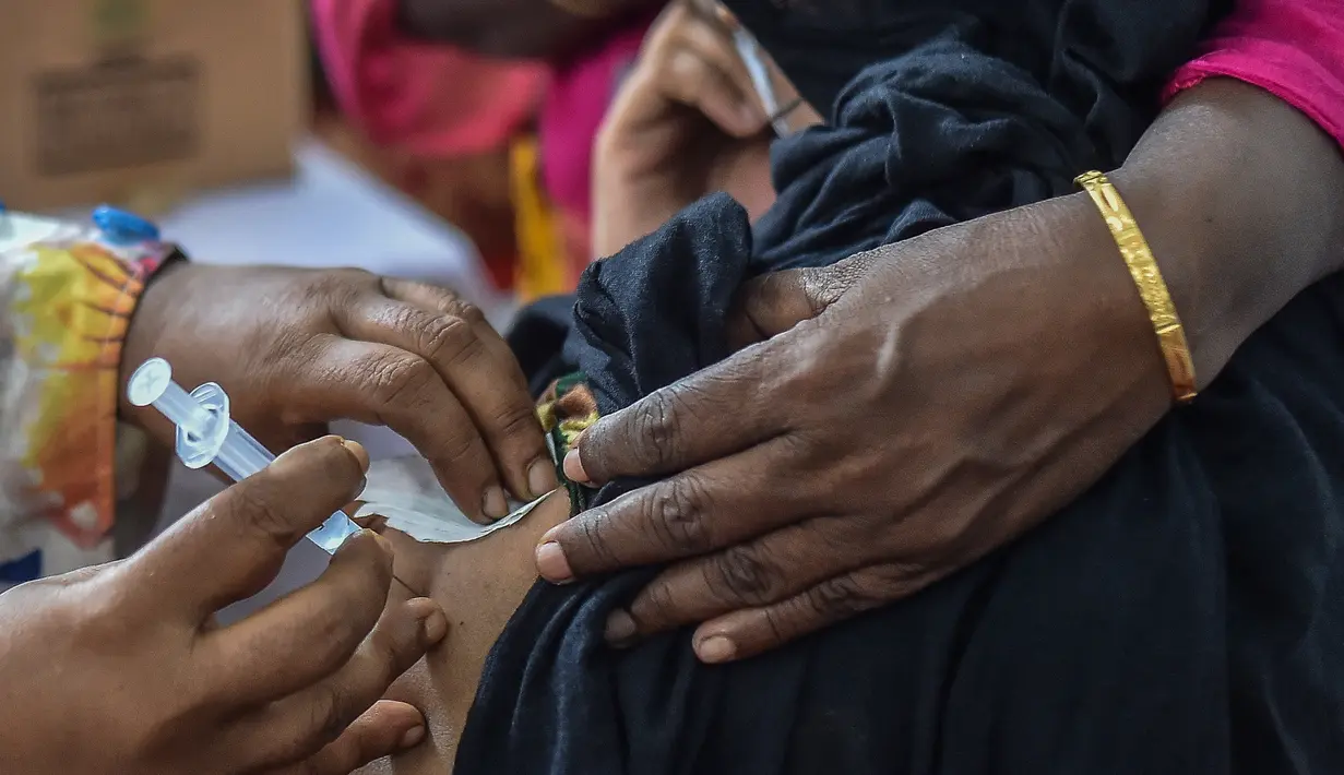 Petugas kesehatan menyuntikkan vaksin COVID-19 kepada seorang pekerja seks komersial (PSK) di Daulatdia, Bangladesh, 18 Agustus 2021. Bangladesh terus menggencarkan vaksinasi COVID-19, kegiatan ini turut menyasar para PSK di pusat prostitusi. (Munir Uz zaman/AFP)