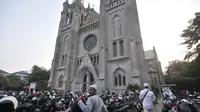 Umat muslim yang akan menunaikan salat Idul Adha di Masjid Istiqlal memarkirkan kendaraan mereka di halaman Gereja Katedral, Jakarta, Minggu (11/8/2019). Untuk membantu jemaah melaksanakan ibadah, Katedral menyediakan lahan parkirnya dan mengundurkan waktu ibadah Misa. (merdeka.com/Iqbal S Nugroho)