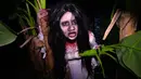 Seorang wanita mengenakan kostum menyeramkan saat preview media 'Halloween Horror Nights' di Universal Studio, Singapura, Senin (24/9). Wahana rumah hantu yang ada akan menghadirkan cerita horor khas Asia seperti Kuntilanak. (AFP/Roslan RAHMAN)