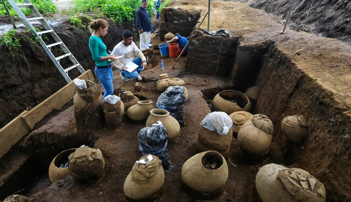 Pekerja Nicaraguan Institute of Culture (INC) mendata sejumlah tembikar di situs pemakaman zaman pra-Kolombia berusia lebih dari 1.200 tahun yang ditemukan di lokasi pembangunan Stadion Bisbol Nasional yang baru di Managua, Selasa (20/6). (INTI OCON/AFP)