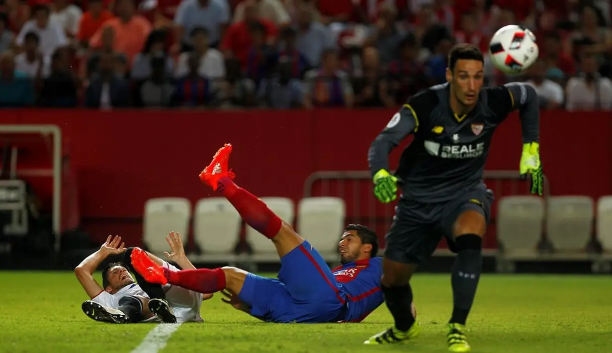 Striker Barcelona, Luis Suarez, terjatuh saat berebut bola di depan gawang Sevilla pada laga leg pertama Piala Super Spanyol 2016 di Ramon Sanchez Pizjuan, Sevilla, Senin (15/8/2016) dini hari WIB. (Reuters/Jon Nazca) 