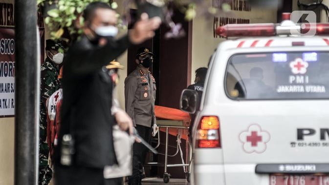 Tim forensik membawa kantong jenazah berisi serpihan Sriwijaya Air SJ 182 dan diduga tubuh korban dari ambulans di RS Polri, Jakarta, Minggu (10/1/2021). (merdeka.com/Iqbal S. Nugroho)