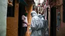Petugas kesehatan India yang mengenakan alat pelindung diri melakukan pemeriksaan COVID-19 di kawasaan permukiman kumuh di tengah penyebaran wabah tersebut di Mumbai, India (17/6/2020). (Xinhua/Stringer)