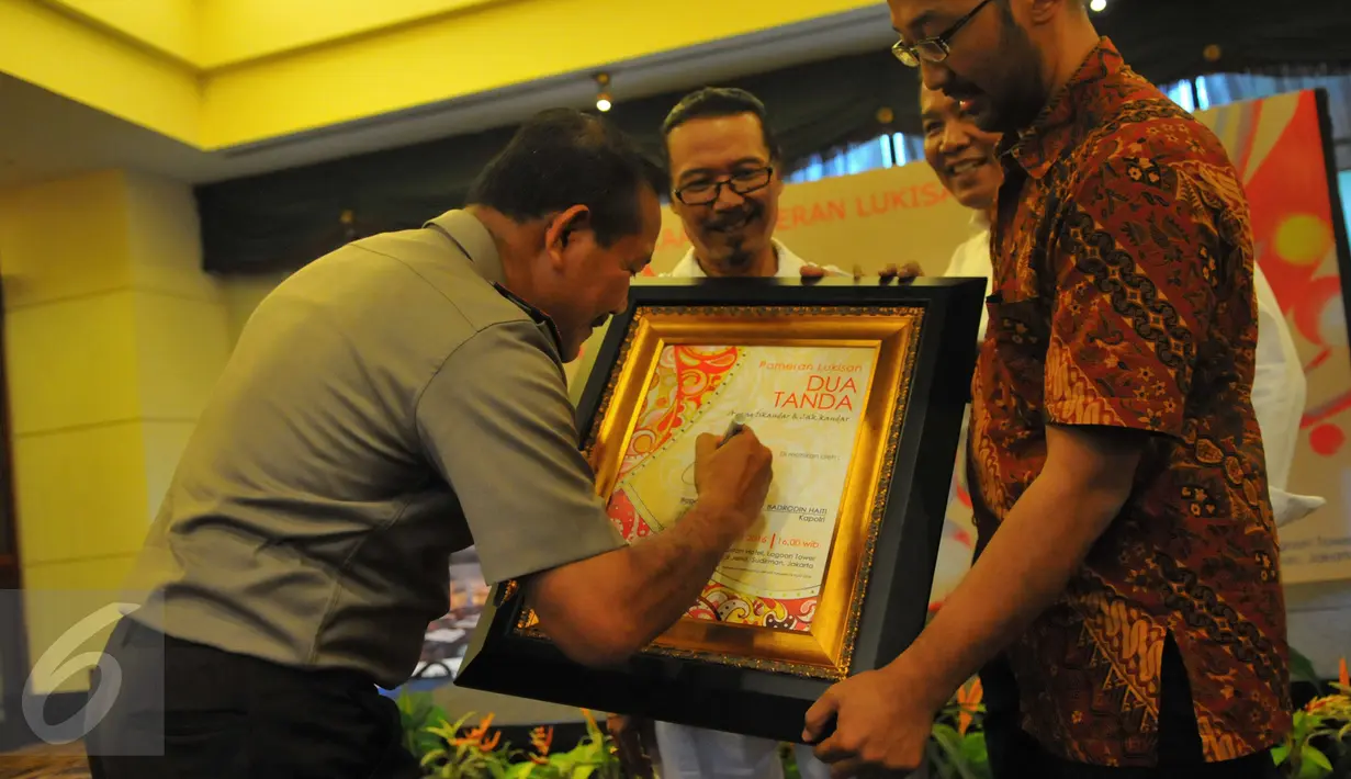 Kapolri Jenderal Badrodin Haiti membubuhkan tanda tangannya pada Piagam Peresmian Pameran Lukisan Dua Tanda di Hotel Sultan Jakarta, Senin (21/3/2016). Badrodin Haiti menyambut baik keberadaan Pameran Lukisan Dua Tanda. (Liputan6.com/Faisal R Syam)