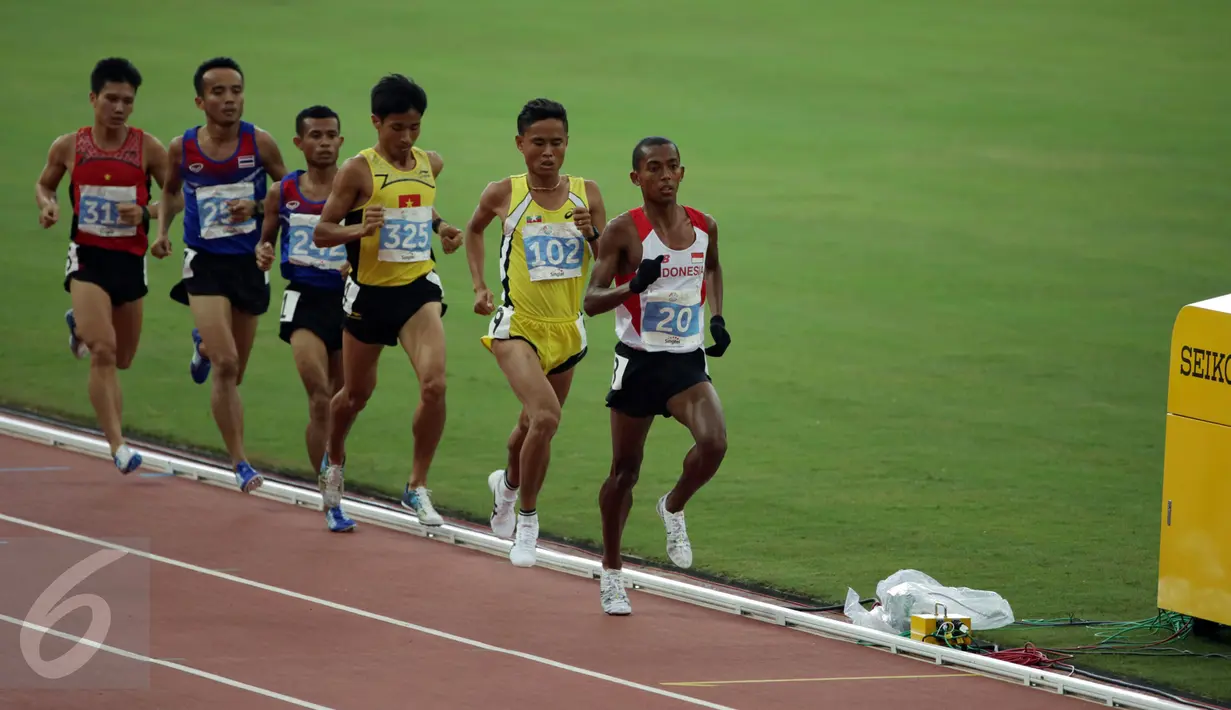 Pelari Indonesia, Agus Prayogo (depan) saat memimpin lomba lari 10.000 m putra di National Stadium, Singapura, Rabu (10/6/2015). Agus berhasil finis dan meraih emas di nomor lari 10.000 m putra SEA Games 2015. (Liputan6.com/Helmi Fithriansyah)  