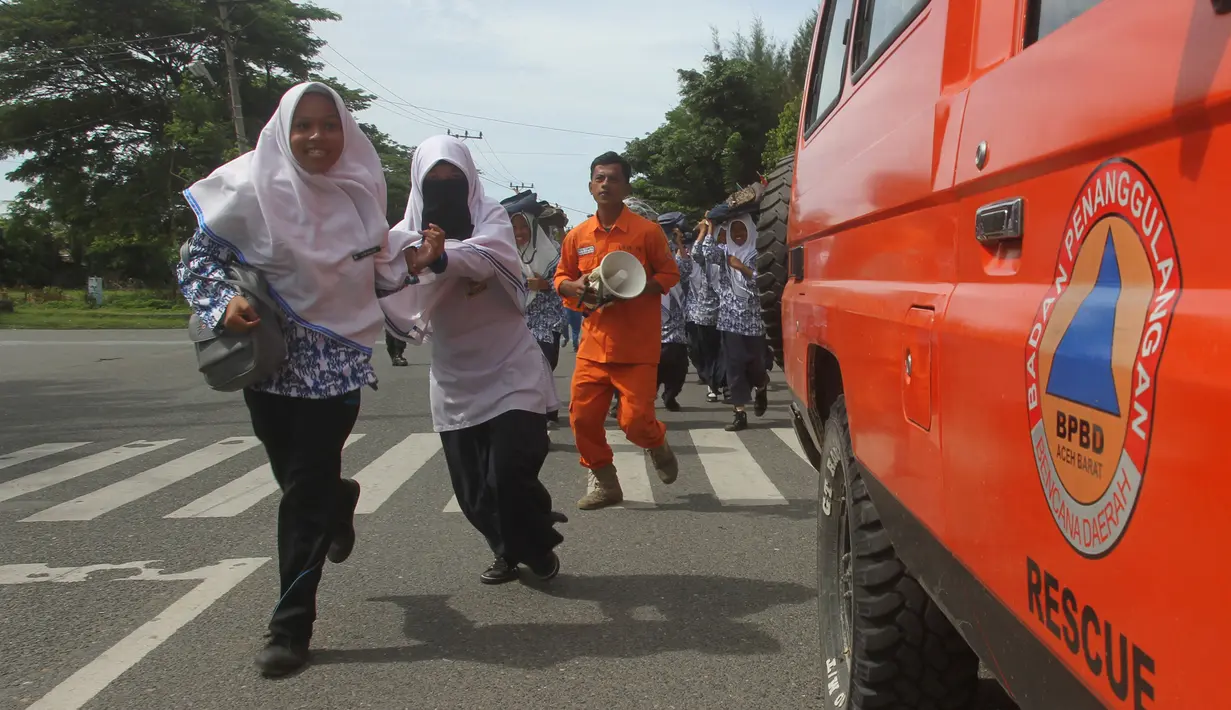 Sejumlah murid berlari saat berpartisipasi dalam latihan tsunami di Meulaboh, Aceh, (5/9). Latihan ini menyimulasikan gempa berkekuatan 9,3 di lepas pantai barat pulau Sumatra di Indonesia. (AFP Photo/Januar)