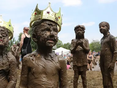 Molly Kofahl dan Charles Daviskiba berpose setelah dinobatkan sebagai Mud Day Queen dan King pada perayaan Hari Lumpur Tahunan di Westland, Michigan, AS, Selasa (10/7). Dalam Mud Day kali ini para pesertanya yang ikut adalah anak-anak.  (AP/Carlos Osorio)