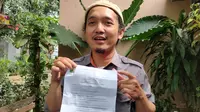 Muhammad Sabil Fadhillah menunjukkan surat pemberhentian dari SMK Telkom Cirebon imbas kritiknya di kolom komentar akun IG Ridwan Kamil. Foto (Liputan6.com / Panji Prayitno)