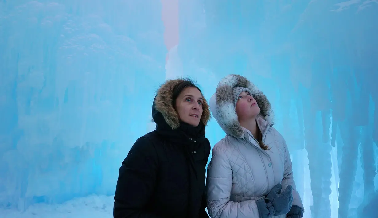 Olha Ratushko dan putrinya Zhenya menjelajahi Kastil Es di Excelsior, Minn (18/1). Kastil tersebut meliputi patung-patung LED-menyala yang menakjubkan, singgasana beku, terowongan pahatan es, seluncuran, air mancur. (Anthony Souffle / Star Tribune via AP)