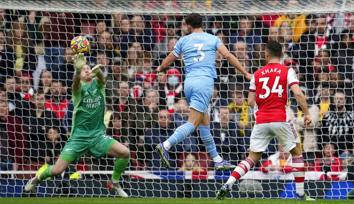 Pemain Arsenal Granit Xhaka (kanan) menyaksikan pemain Manchester City Ruben Dias (tengah) gagal mencetak gol melewati kiper Arsenal Aaron Ramsdale pada pertandingan sepak bola Liga Inggris di Stadion Emirates, London, Inggris, 1 Januari 2022. Manchester City menang 2-1. (AP Photo/Matt Dunham)
