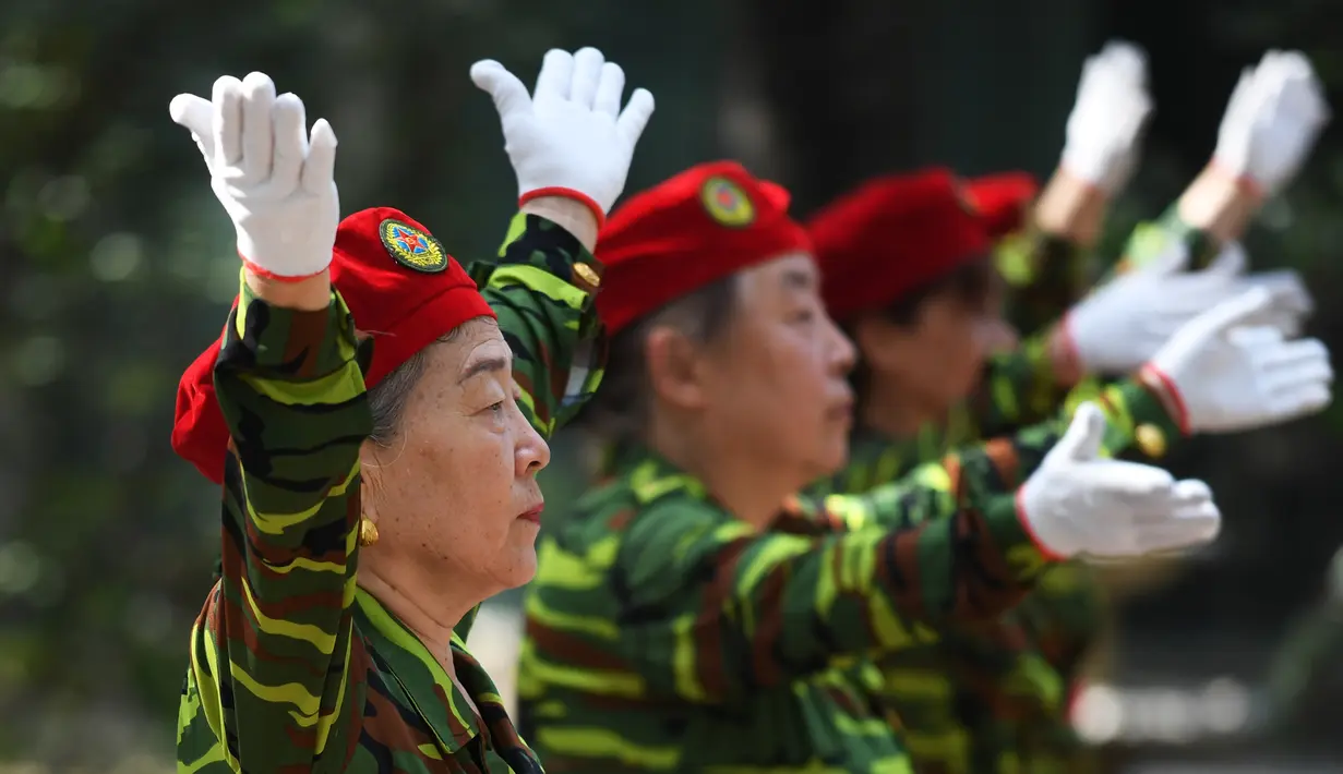 Sejumlah wanita lansia tampil mengenakan pakaian bergaya militer saat mengkuti Hari Kebugaran Nasional di Beijing, Tiongkok (8/8). Para lansia ini tampil lincah dalam peringantan Hari Kebugaran Nasional tersebut. (AFP Photo/Greg Baker)