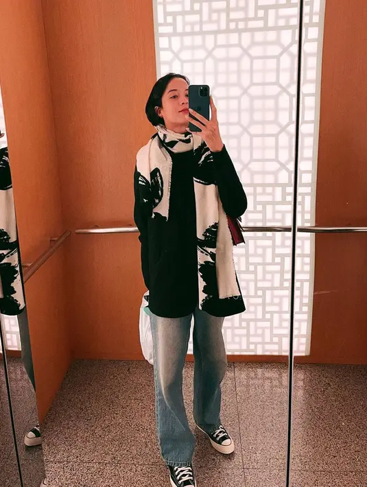 Gaya simpel yang tak kalah memesona dari Putri Marino ketika berada di Busan. Ia mengenakan oversized sweater hitam, dipadu padankan dengan celana jeans, dan ia menambahkan syal bermotif berwarna hitam-putih di lehernya. [Foto: Instagram/putrimarino]