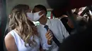 Thiago do Nascimento dan Keilla de Almeida berciuman saat pernikahan drive-thru mereka di kantor pencatatan sipil di Santa Cruz, Rio de Janeiro, Brasil, 28 Mei 2020. Fasilitas ini untuk memudahkan dan membantu pasangan yang ingin mengesahkan hubungan saat pandemi covid-19. (AP/Silvia Izquierdo)