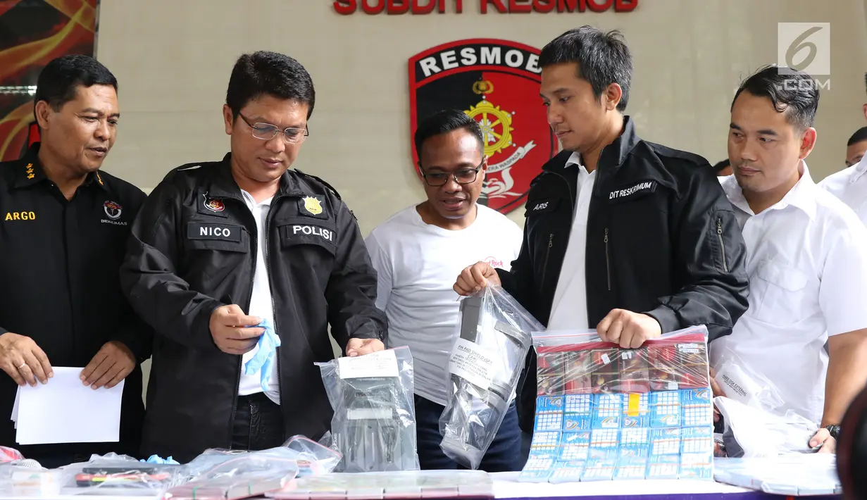 Petugas menunjukkan barang bukti pembobol uang dari mesin ATM dengan teknik skimming diperlihatkan petugas Resmob Polda Metro Jaya saat rilis di Jakarta, Sabtu (17/3). Kasus melibatkan empat WNA dan seorang WNI. (Liputan6.com/Helmi Fithriansyah)