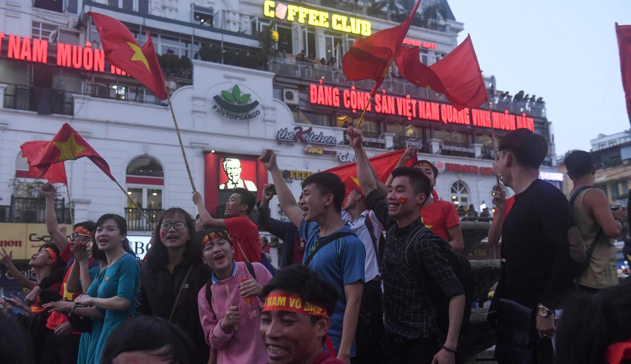 Sejumlah warga merayakan keberhasilan Vietnam mengalahkan Qatar pada semifinal Piala AFC U-23 di Hanoi, Rabu (23/1/2018). Vietnam berhasil lolos ke final untuk menantang pemenang antara Uzbekistan dan Korea Selatan. (AFP/Hoang Dinh Nam)