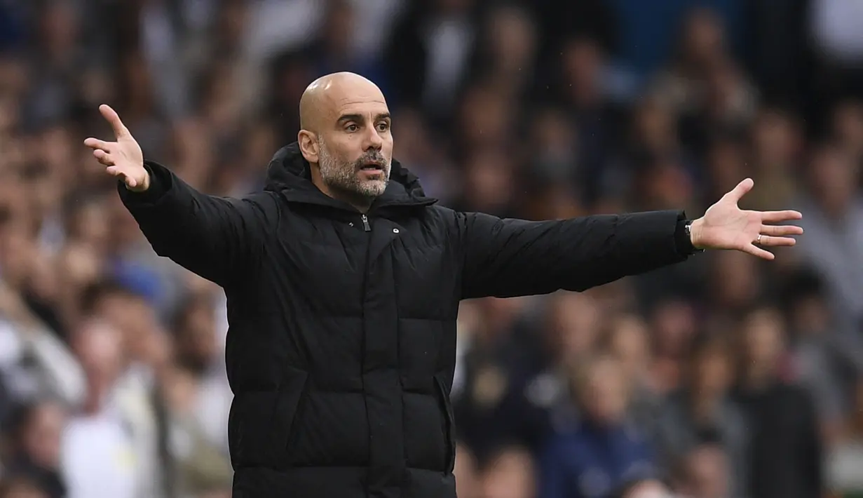 <p>Pelatih Manchester City, Pep Guardiola memberi isyarat di pinggir lapangan saat bertanding melawan Leeds United pada pertandingan lanjutan Liga Inggris di Elland Road di Leeds, Inggris utara (30/4/2022). The Citizens yang mengoleksi 83 poin berada di atas The Reds dengan 82 poin. (AFP/Oli Scarff)</p>