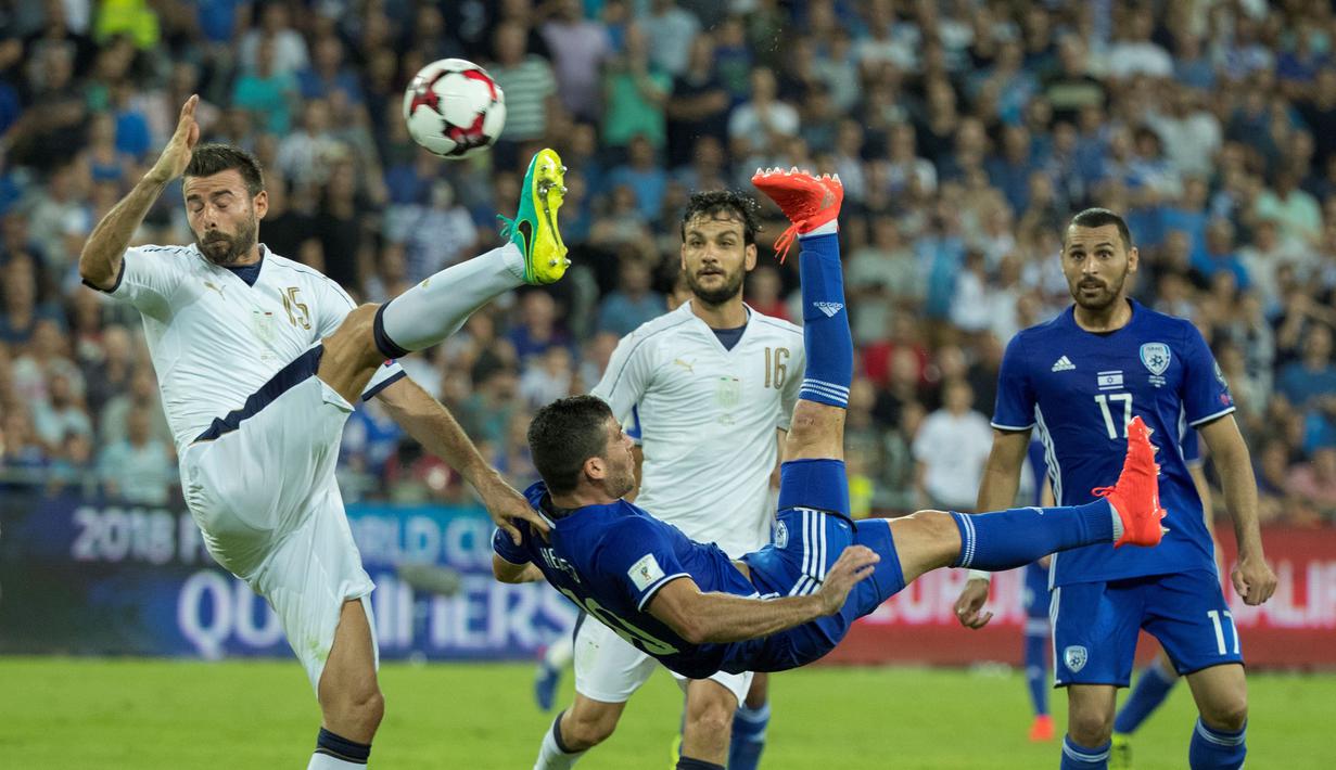 Pemain Israel, Tomer Hemed (tengah), melakukan tendangan salto saat dihadang pemain Italia, Andrea Barzagli (kiri) pada Kualifikasi Piala Dunia 2018 di Stadion Sammy Ofer, Haifa, Israel, Selasa (6/9/2016) dini hari WIB. (AFP/Jack Guez)