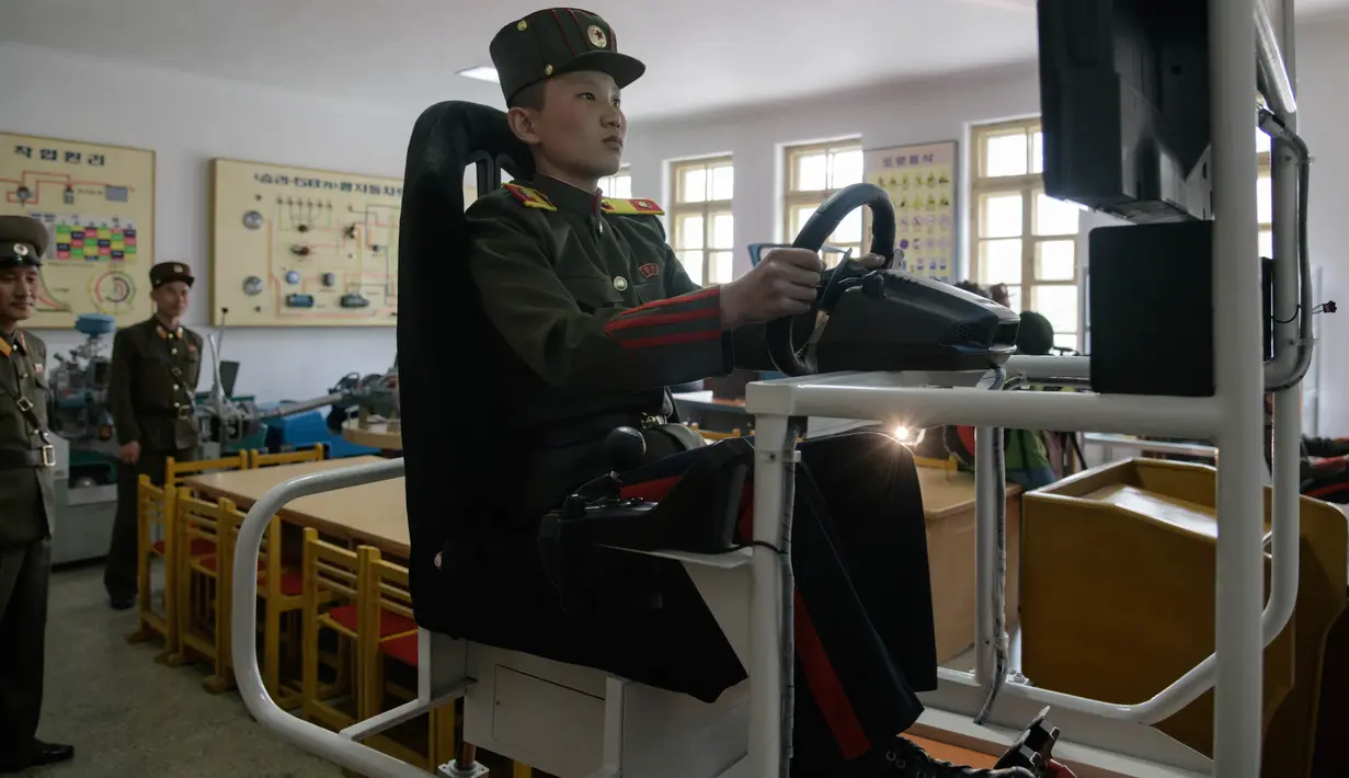 Siswa berlatih mengendarai simulator kendaraan militer di Sekolah Revolusioner Mangyongdae, 10 April 2018. Didirikan oleh pendiri Korea Utara, Kim Il Sung untuk mendidik anak-anak yatim piatu yang orangtuanya terbunuh dalam perang Jepang. (ED JONES/AFP)