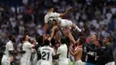 Sejumlah pemain Real Madrid melempar rekan satu timnya, Marco Asensio, ke udara sebagai bentuk perpisahan setelah menjalani pertandingan terakhirnya bersama Real Madrid di Santiago Bernabeu, Minggu (4/6/2023) malam WIB. (AFP/Pierre-Philippe Marcou)