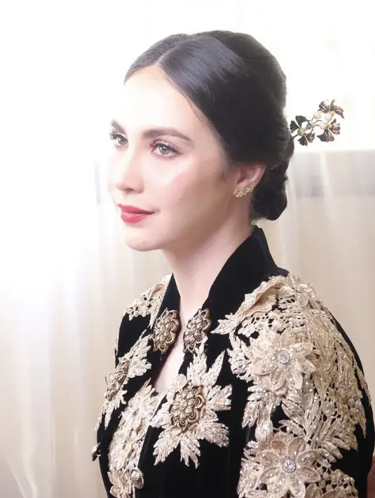 <p>Dengan gaya rambut sanggul modern belah tengah. Ditambah dengan aksesoris tusuk konde keemasan mutiaranya. @hanzulmi</p>