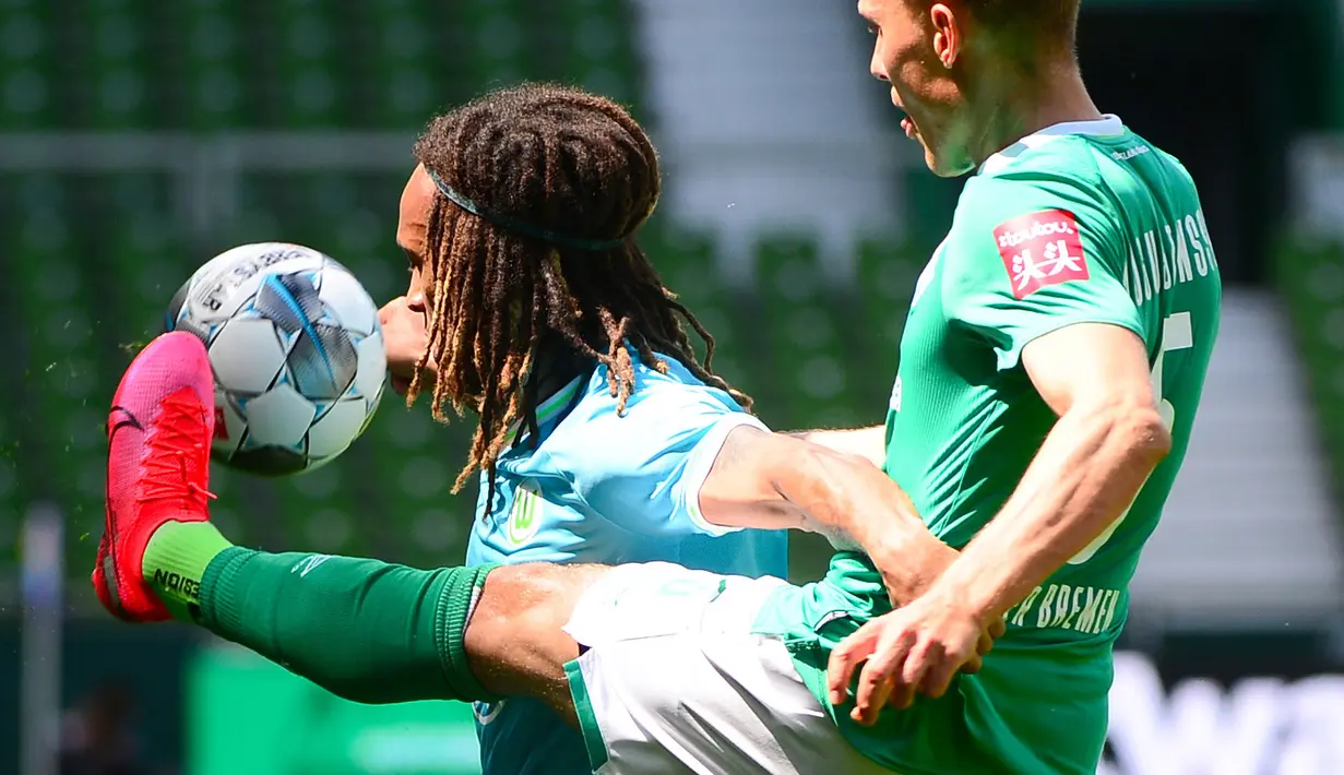 Pemain Werder Bremen,  Ludwig Augustinsson, berebut bola dengan pemain Wolfsburg, Kevin Mbabu, pada laga Bundesliga di Weserstadion Minggu (7/6/2020). Werder Bremen takluk 0-1 dari Wolfsburg. (AFP/Patrik Stollarz)