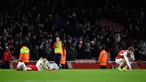 Gelandang Arsenal, Theo Walcott (kiri) dan Nacho Monreal terlihat sedih usai pertandingan melawan Swansea City pada lanjutan liga Inggris di Stadion Emirates (2/3). Swansea menang atas Arsenal dengan skor 2-1. (Reuters/Dylan Martinez)