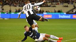 Pemain Juventus, Pol Lirola melompat menghindari terjangan pemain Melbourne Victory, Mitchell Austin pada ajang International Champions Cup football di Melbourne, (23/7/2016). (AFP/Paul Crock)