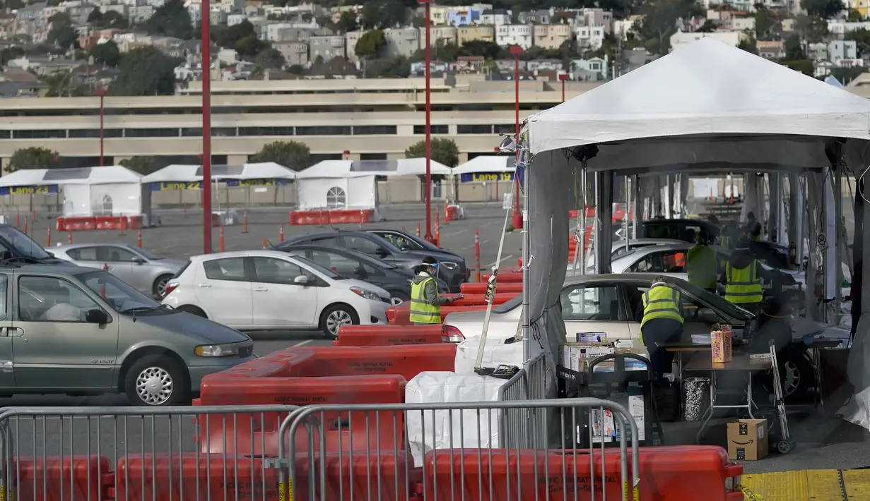 Mobil-mobil menunggu untuk mendapatkan vaksin COVID-19 di pusat vaksinasi drive-thru di City College of San Francisco di San Francisco, Senin (1/2/2021). Ketika pasokan vaksin COVID-19 meningkat, UC San Francisco memperluas upaya vaksinasi kepada mereka yang paling berisiko. (AP Photo/Jeff Chiu)
