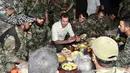 Presiden Suriah Bashar al-Assad (tengah) berbincang saat buka puasa bersama di Desa Marj al-Sultan, timur Ghouta, Damaskus, Suriah, Minggu (26/6).(REUTERS/Sana)