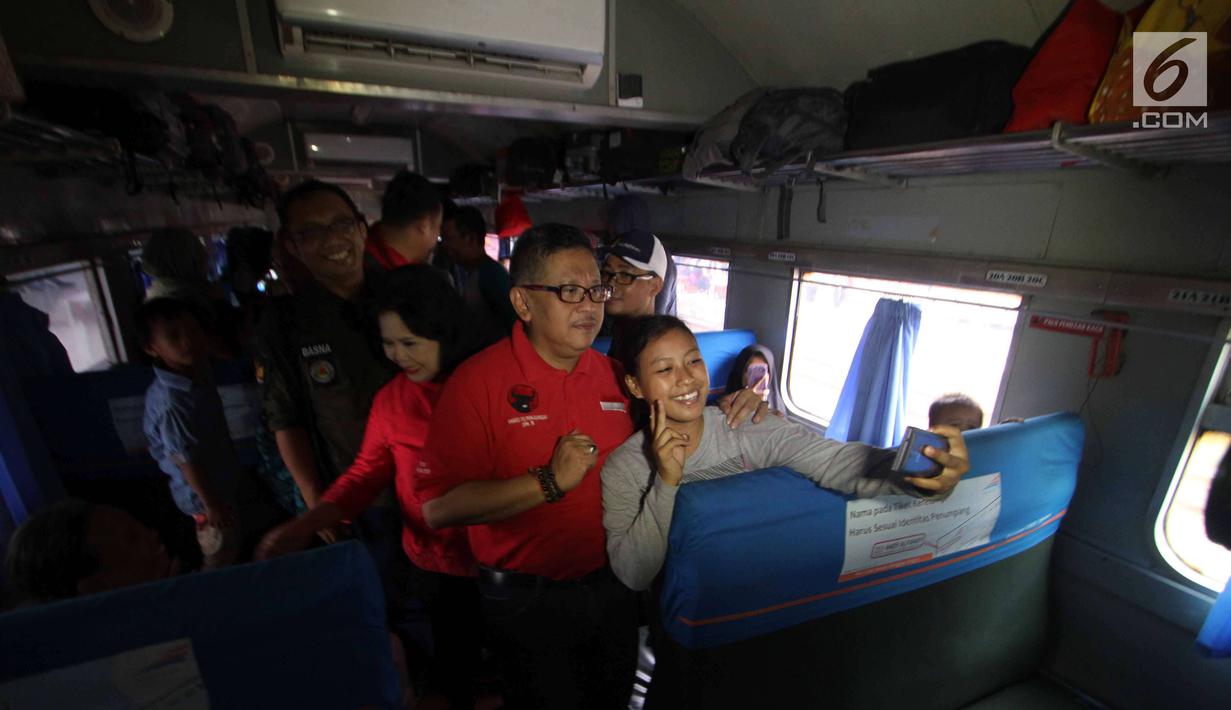 Sekjen DPP PDIP Hasto Kristiyanto foto bersama pemudik saat melepas mudik gratis bareng PDIP di Stasiun Pasar Senen, Jakarta, Selasa (12/6). Mudik garatis ini dengan tujuan Stasiun Surabaya, Malang, Yogyakarta, dan Semarang. (Liputan6.com/Angga Yuniar)